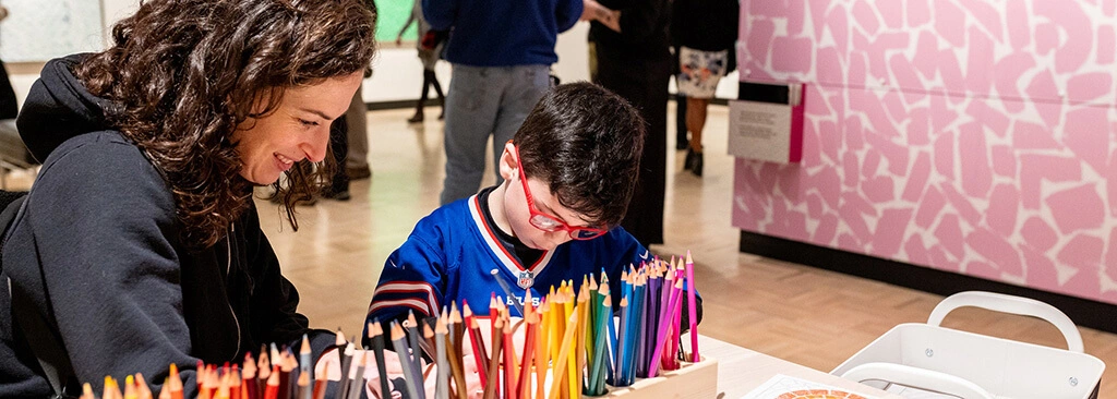 A parent and a child working on art in the Docent Gallery.