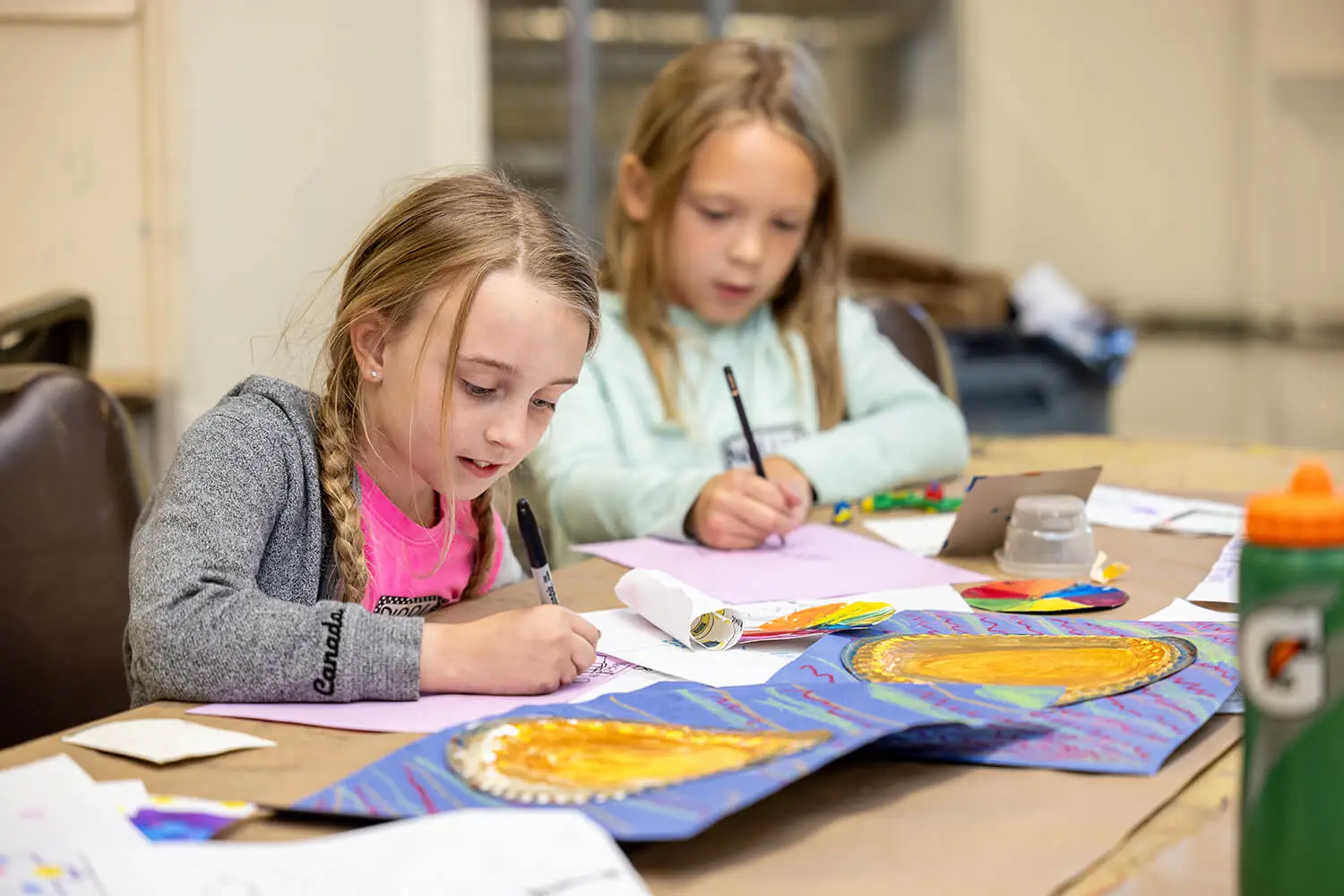 Two girls drawing in the Creative Workshop.