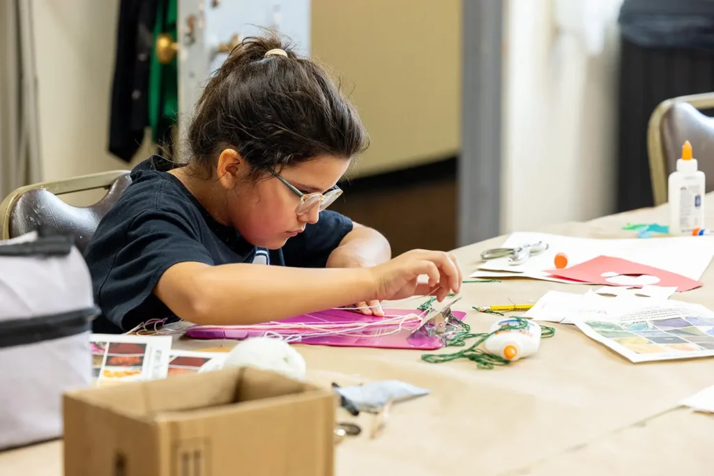 A girl working on an art project in the Creative Workshop.