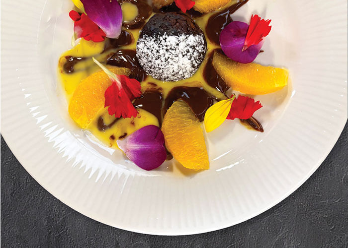 A colorful plate of dessert with fruit and flowers.