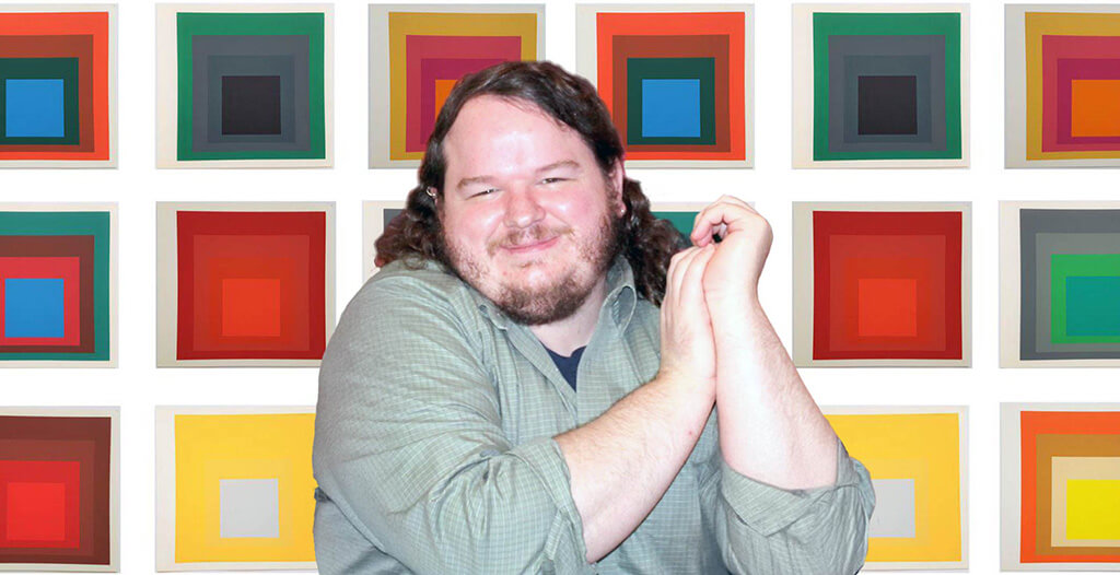 Museum educator Kevin Carr against a background of Josef Albers's color theory painted squares.