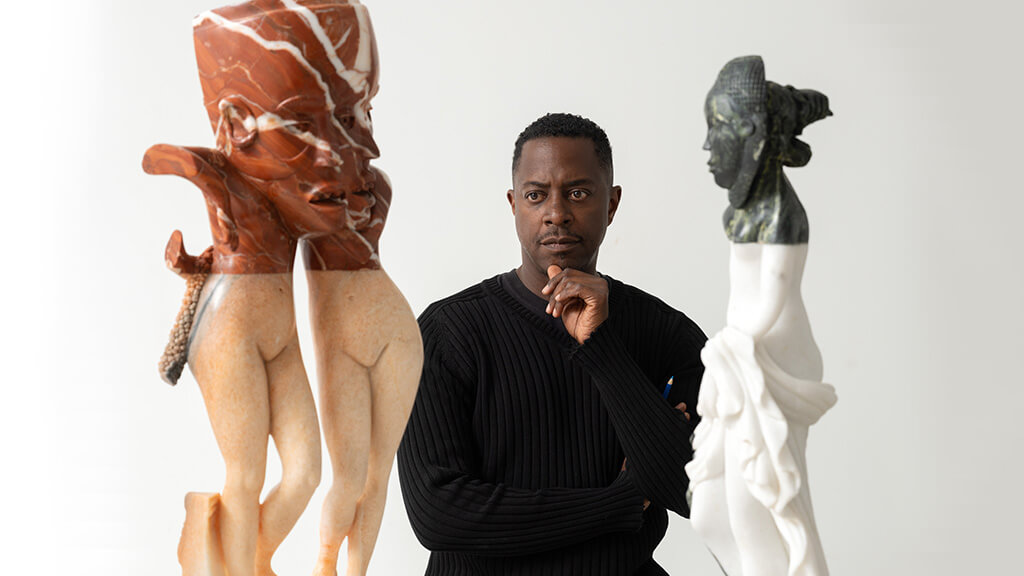 Sanford Biggers, looking at two of his sculptures.
