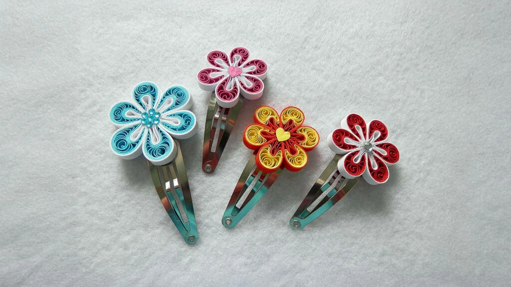 Four floral hair clips, the flower decorations made of quilled paper.