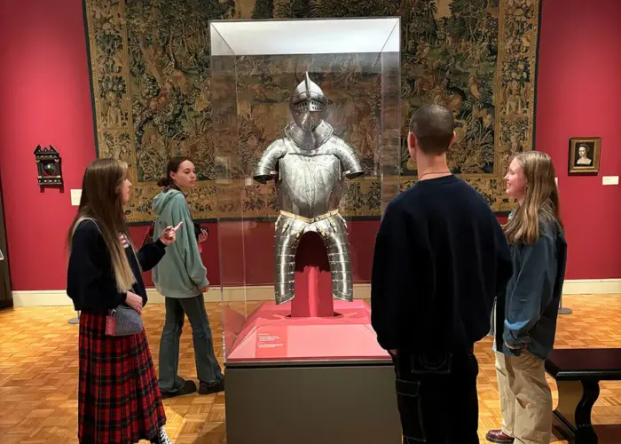 A group of visitors examining the suit of armor in MAG's Renaissance gallery.