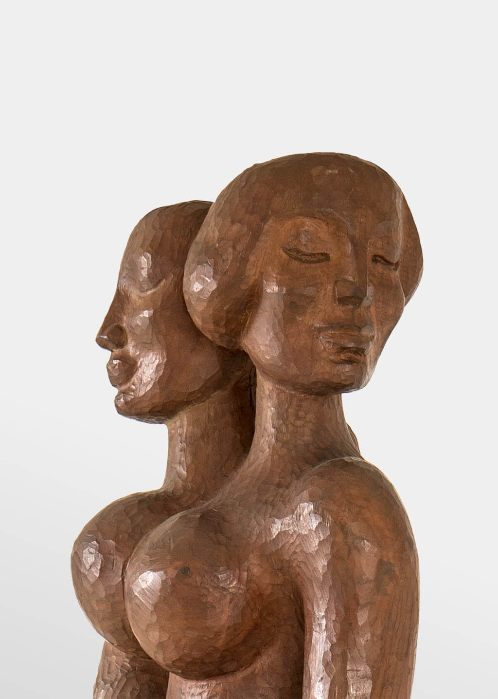 Two serene women's heads, carved out of shining wood.