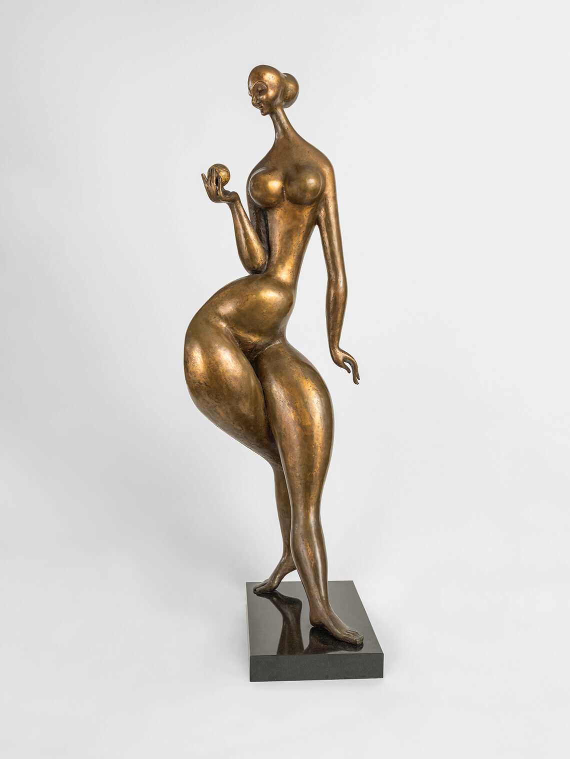 A slightly abstract bronze sculpture of a very curvy woman.
