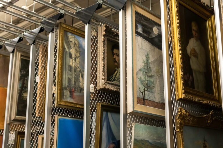 Paintings hanging up in MAG's storage.