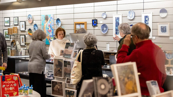 Shoppers in THE STORE @ MAG, looking at the handmade artworks on sale.