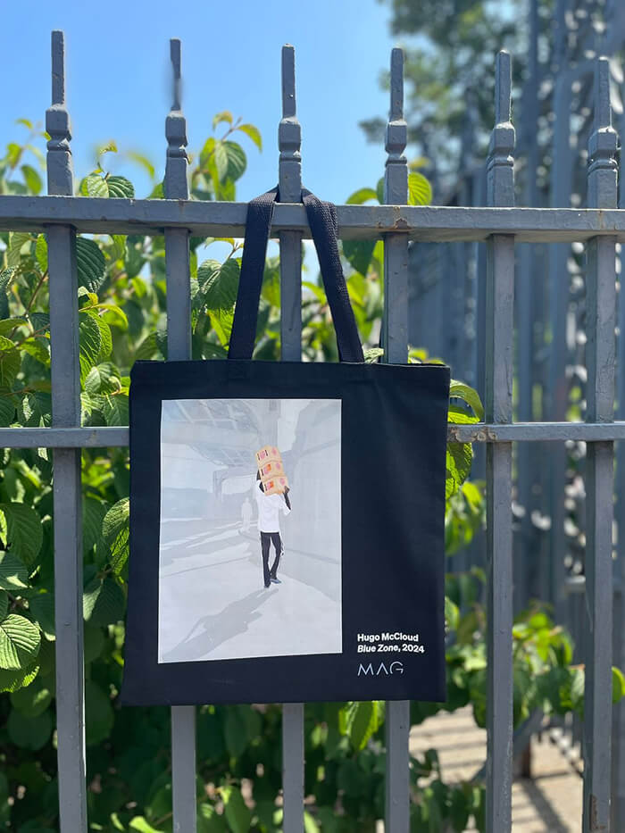 A black tote with Hugo McCloud's "Blue Zone" printed on it.