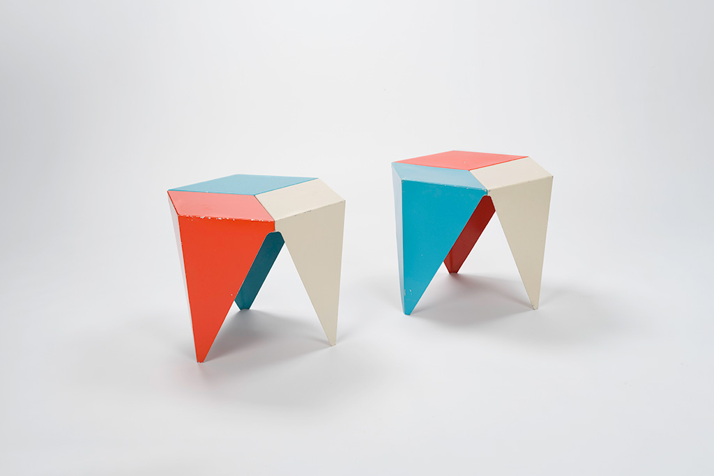 Two hexagonal metal tables that are painted blue, red, and white.