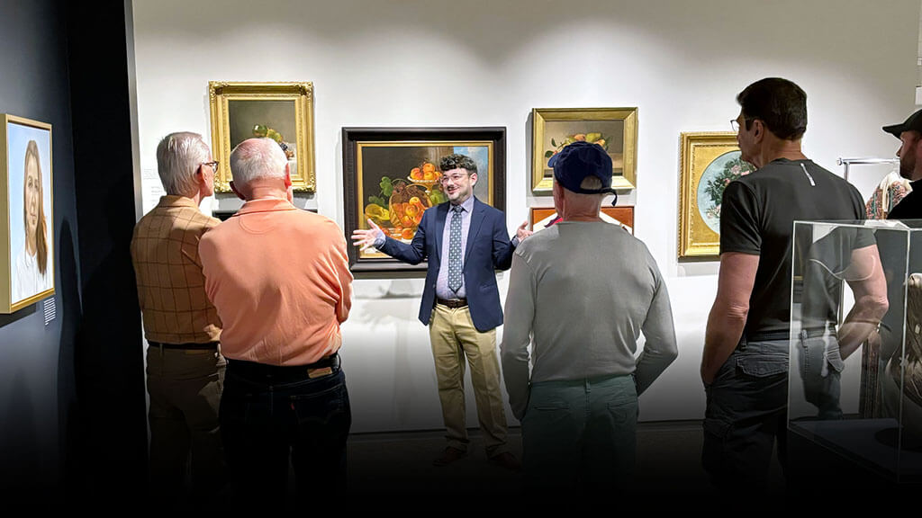 A guide talking about works of art in the galleries with a tour group.