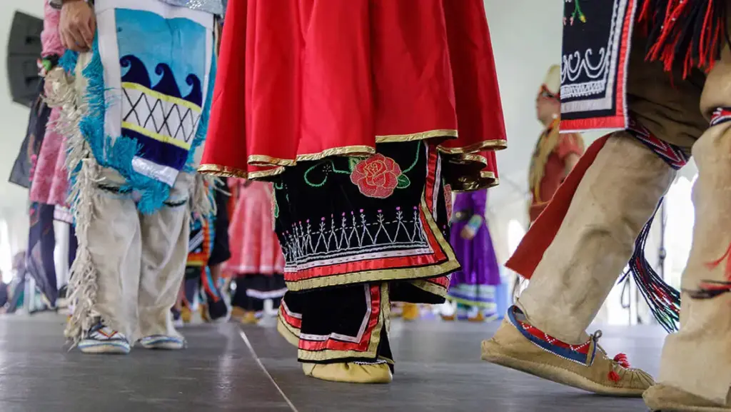 Haudenosaunee dancers in traditional clothing, photographed from the knees down.