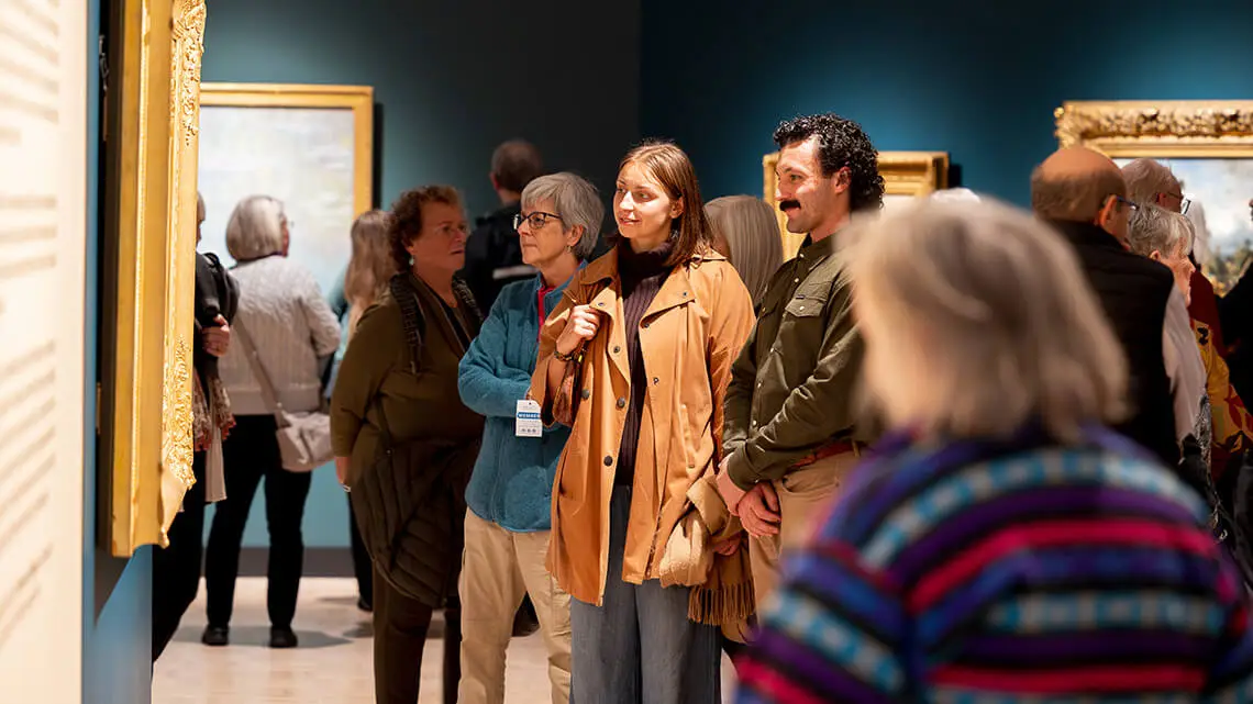 Visitors looking at artwork in the "Frontiers of Impressionism" exhibition.