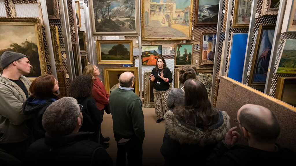 Curatorial assistant Lauren Tagliaferro shows MAG's painting storage to a tour.