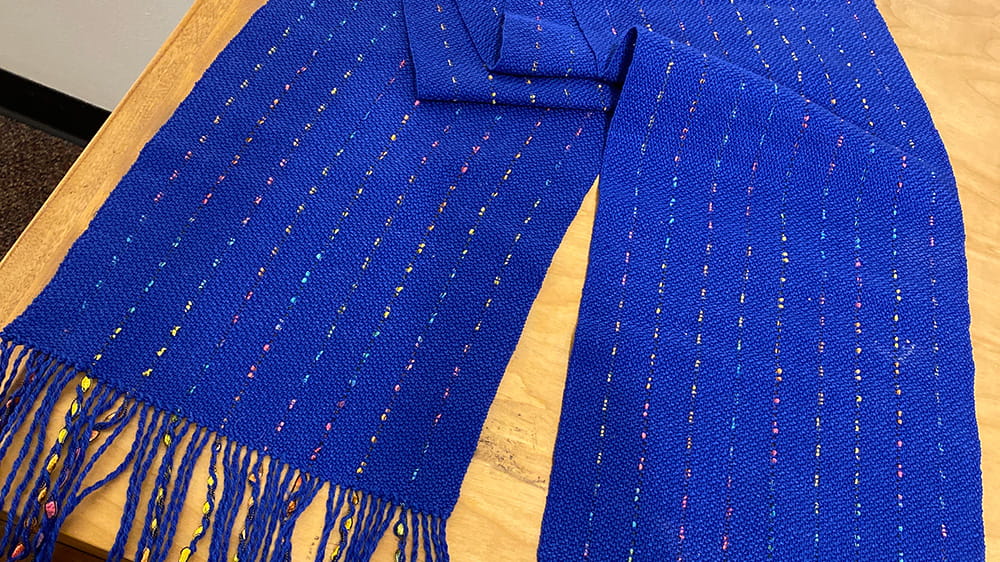 Woven bright blue scarf shot thought with metallic ribbons