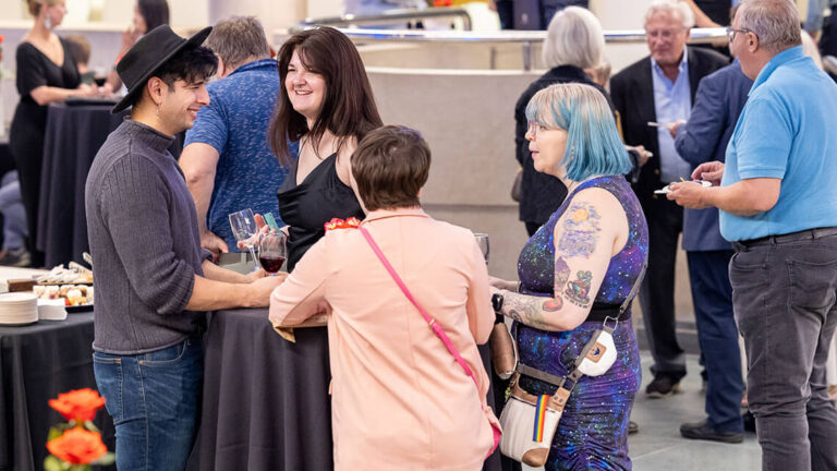 People smiling and mingling in MAG's Vanden Brul Pavilion.