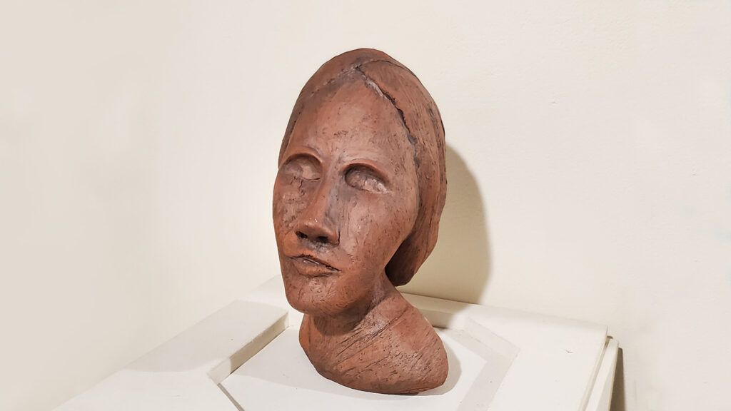 Terracotta sculpture of a woman's head.