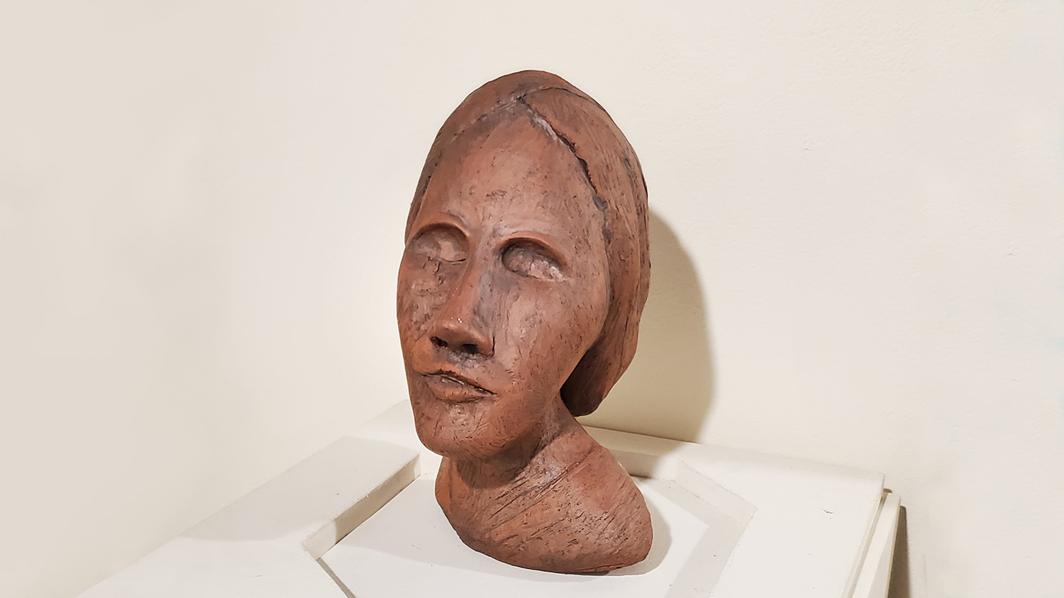 Terracotta sculpture of a woman's head.