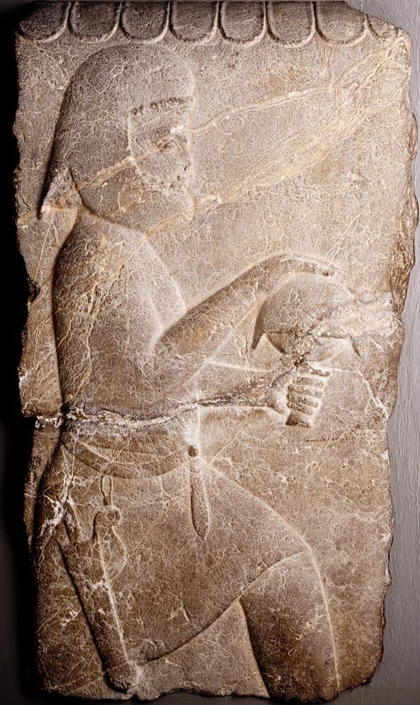 Carved relief of a man in Persian costume ascending a staircase with a tribute gift.