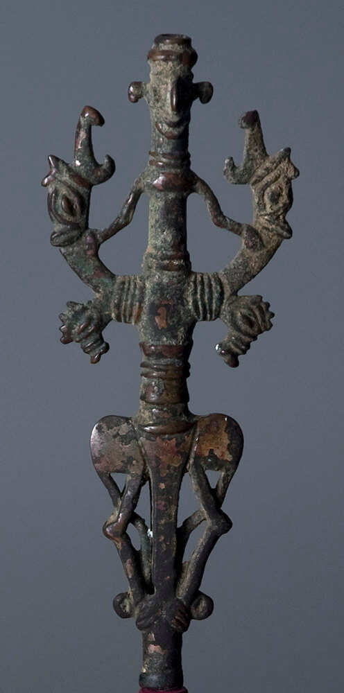 A decorative finial depicting a man, his outstretched arms grasping the neck of a two-headed chimera.