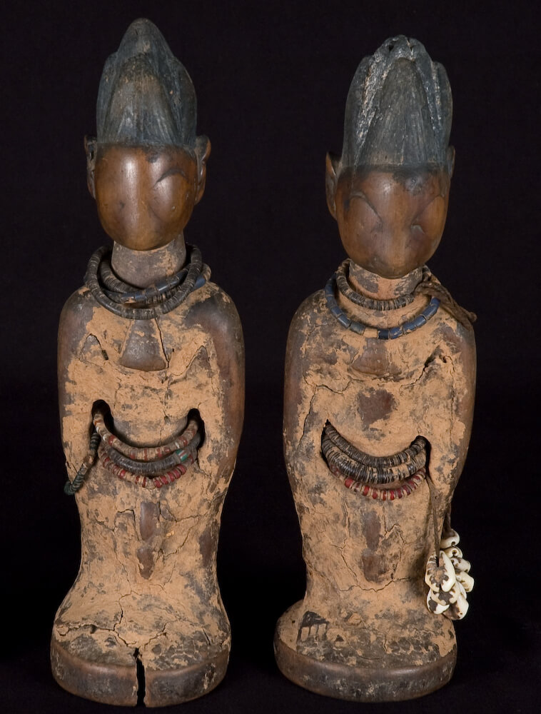 A pair of small, wooden human figures.
