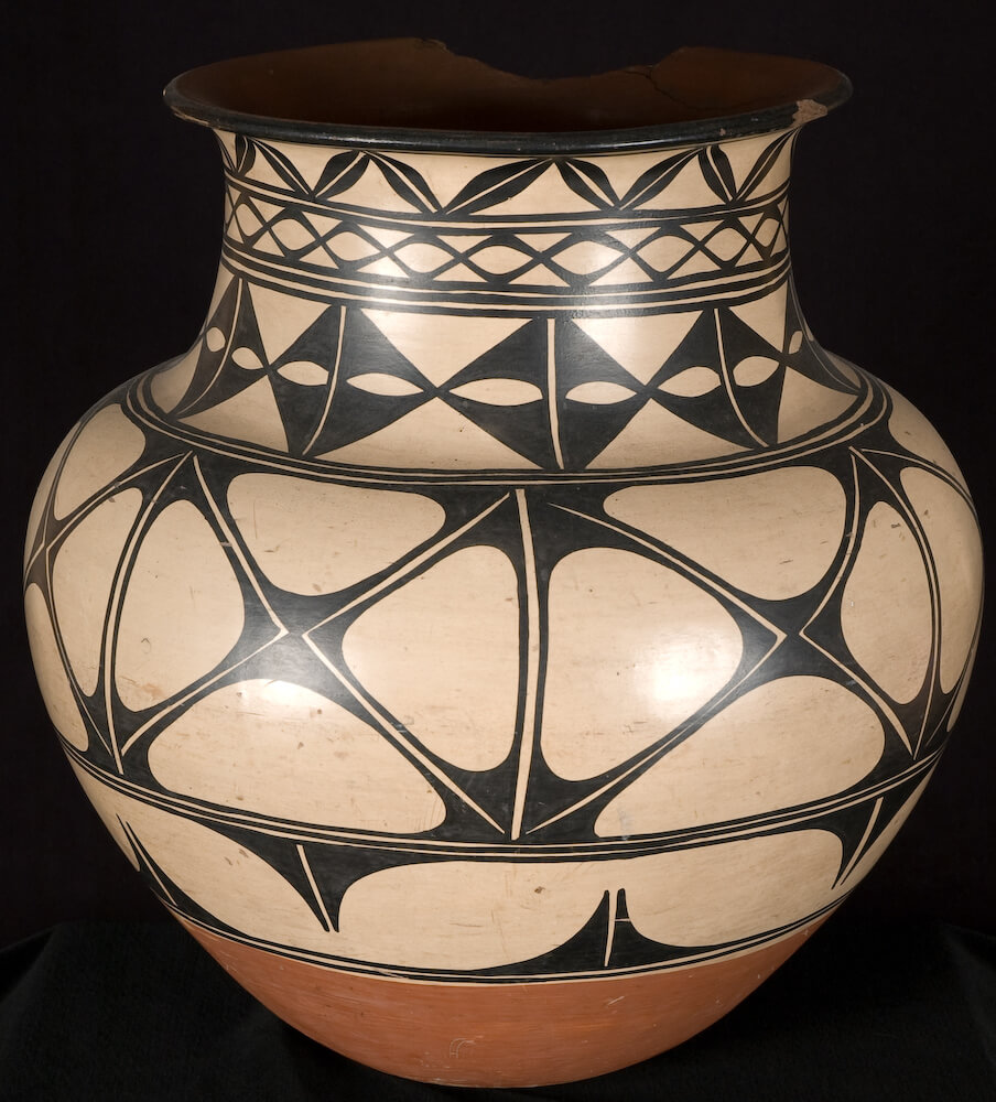 A jar decorated with a cream slip based and dark black geometric patterns.
