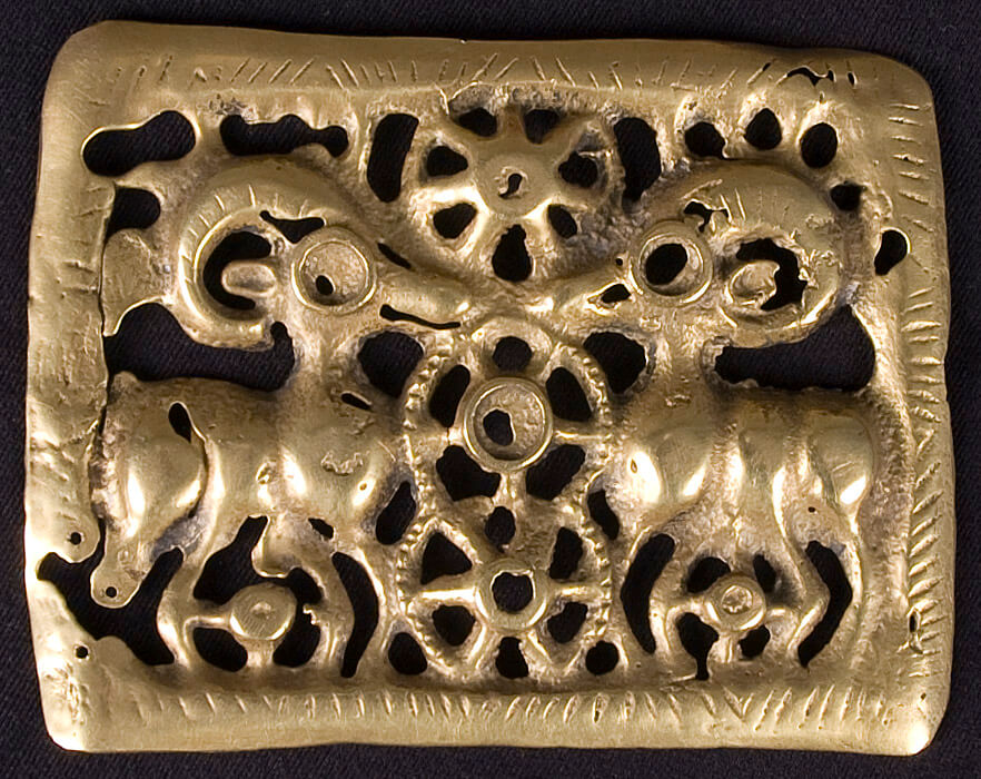 A bronze plaque decorated with two ibexes facing each other, curved horns arching over their backs.