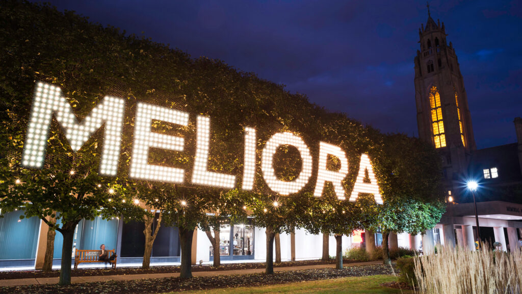 Lights forming the word "Meliora" in the linden trees outside MAG.