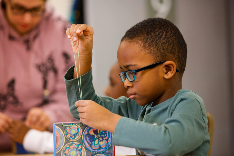A child working on a mixed media project in the Creative Workshop.
