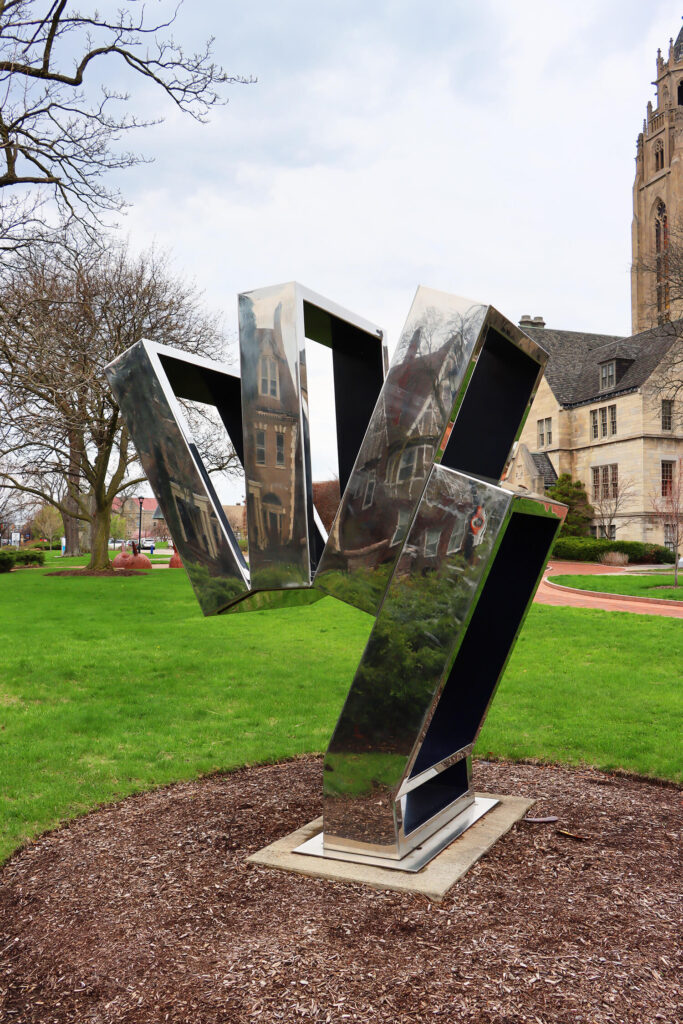 Shining steel sculpture of rectangles angled off each other in an arch.