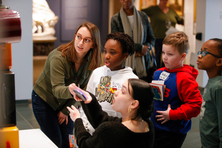 An adult working with kids to learn in the galleries.