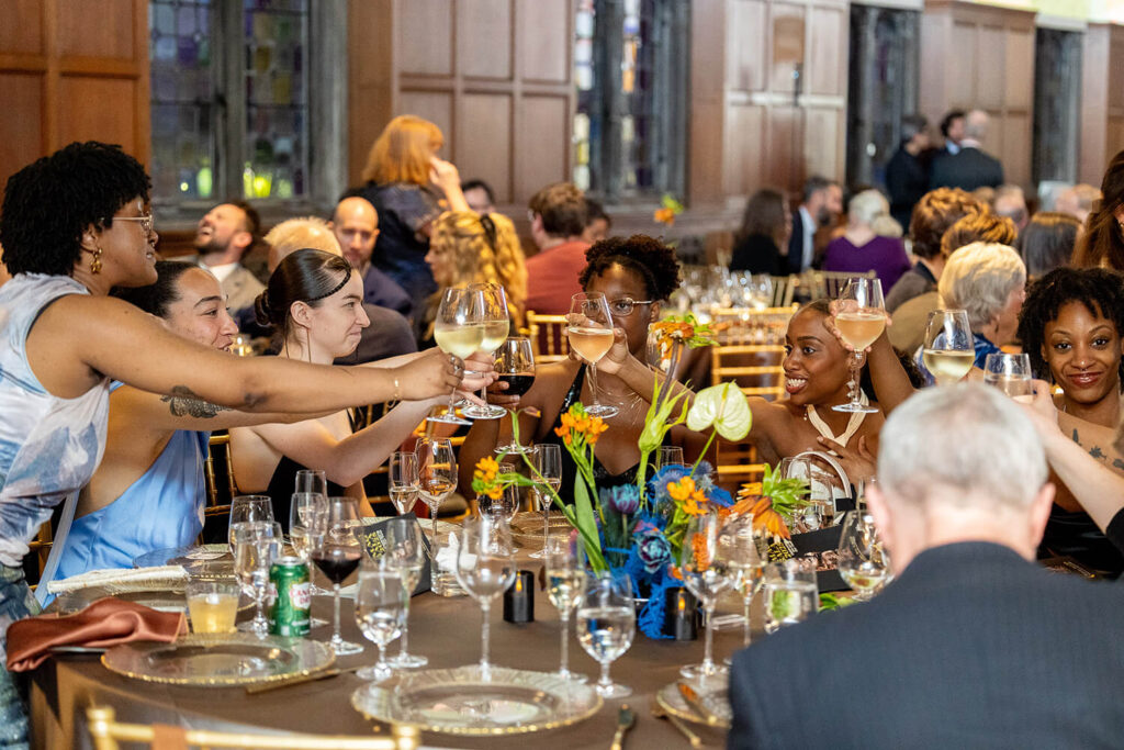 Attendees of the 2025 MAG Gala raising a toast during dinner.
