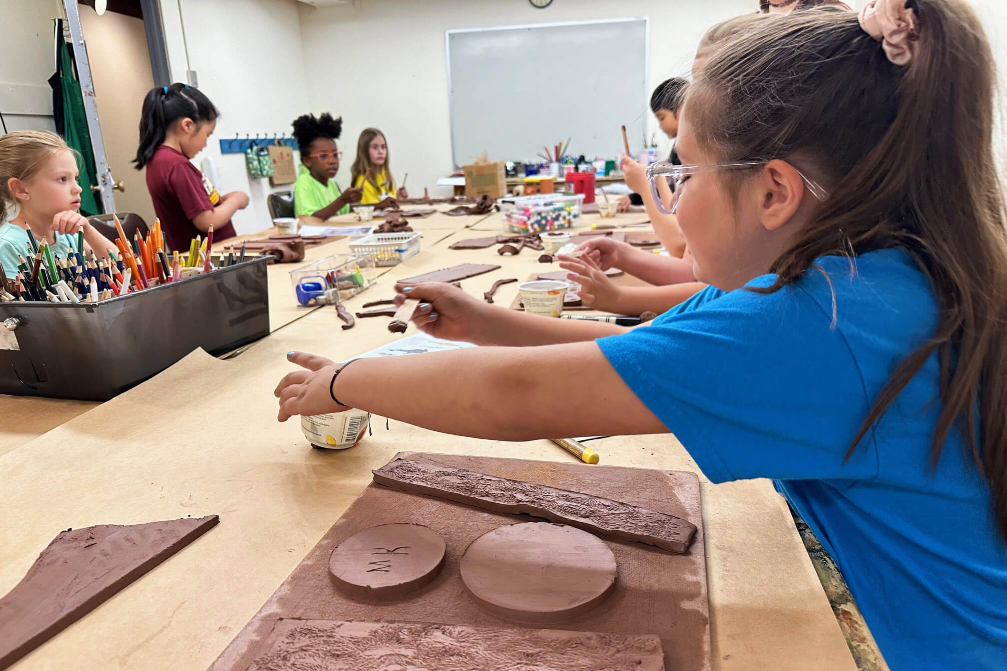 Kids working on ceramic projects in the Creative Workshop.