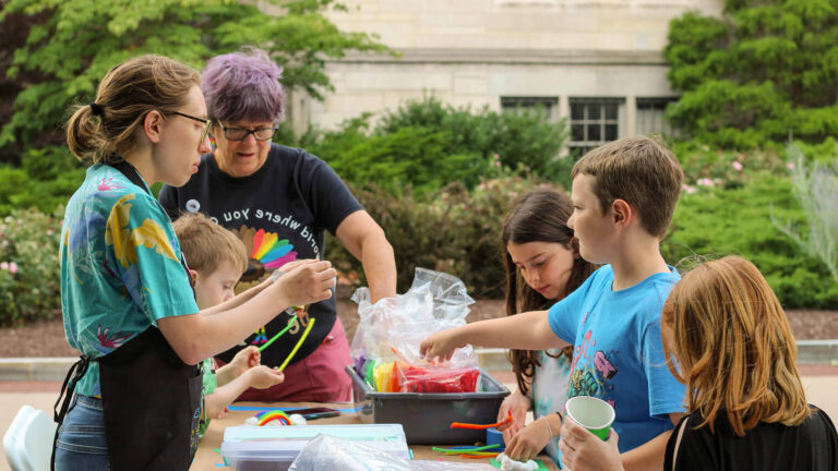 A volunteer helps a family with a craft project at a Celebration Day.