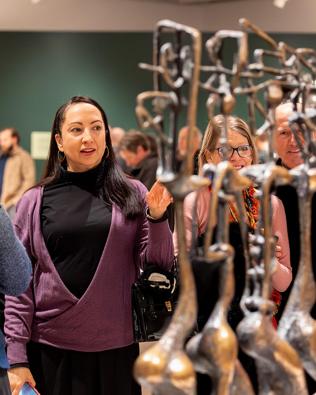 Visitors look at sculpture in the exhibition "Determined to Be: The Sculpture of John Rhoden."