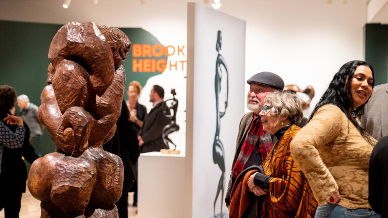 Visitors exploring "Determined to Be: The Sculpture of John Rhoden."