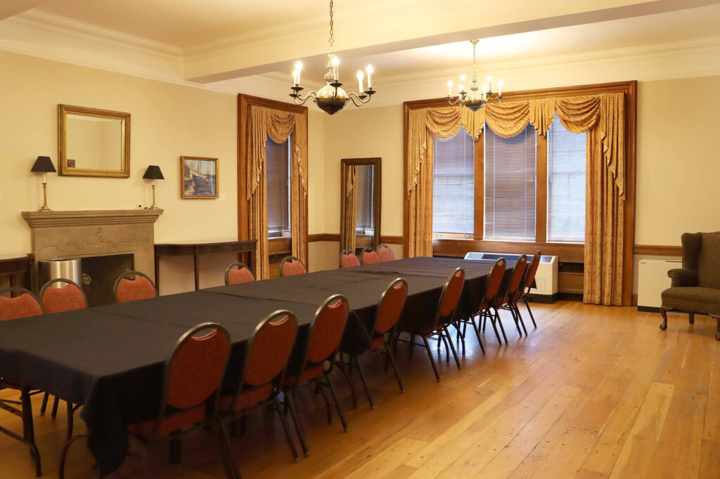 The Lynne Lovejoy Parlor, set up with one long table in the middle, surrounded by chairs.