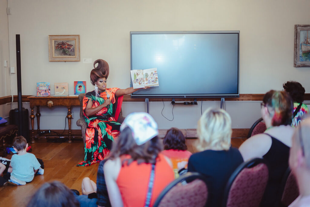 People sitting in the Lynne Lovejoy Parlor for a drag story hour.