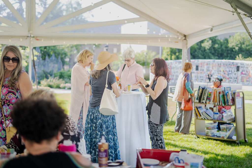 People gathered for an event under a tent on MAG's grounds.