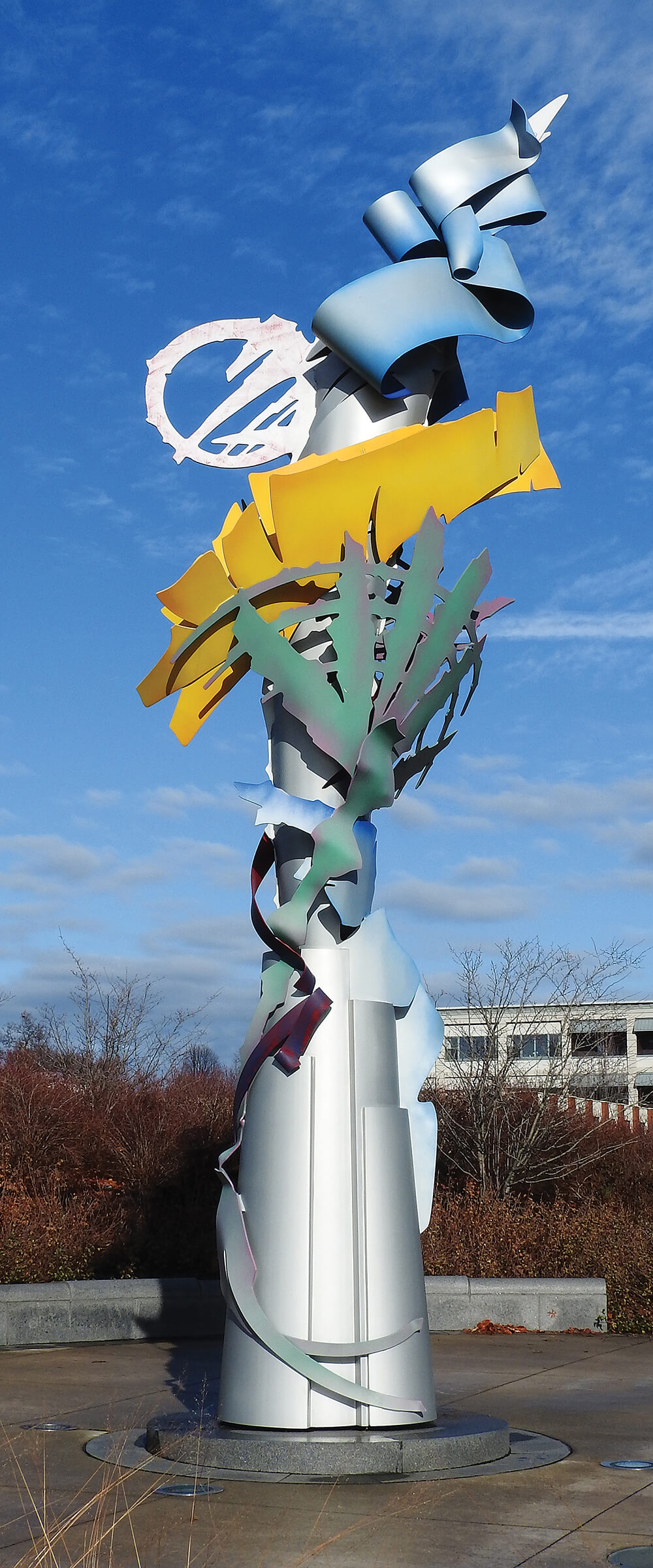 Sculptural steel statue with colorful ribbons stretching into the air