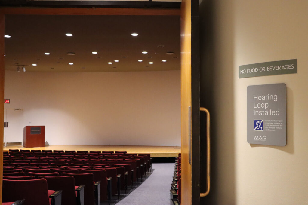 The entrance to MAG's auditorium, showing the Hearing Loop sign next to the open door.