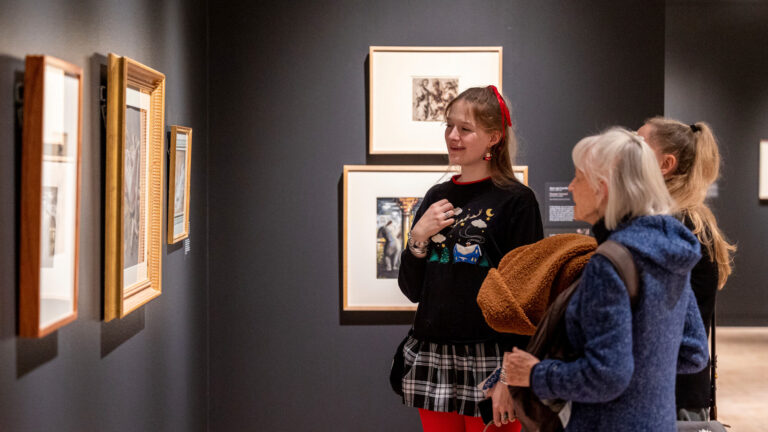 Visitors looking at works of art in one of MAG's galleries.