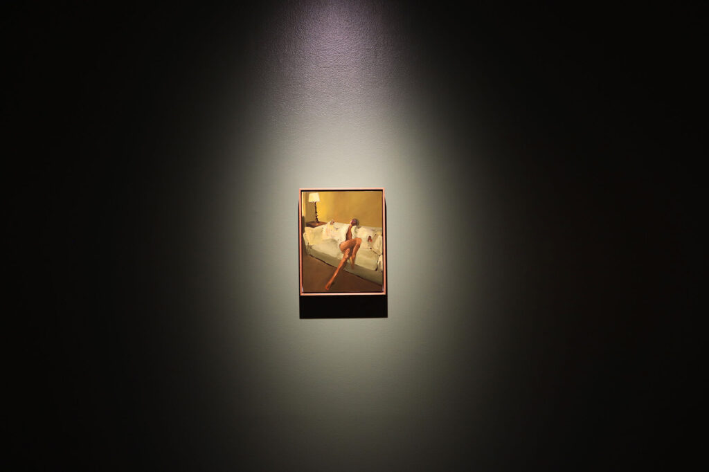 Danielle McKinney's painting "Cloud Nine" spotlit on a dark wall.