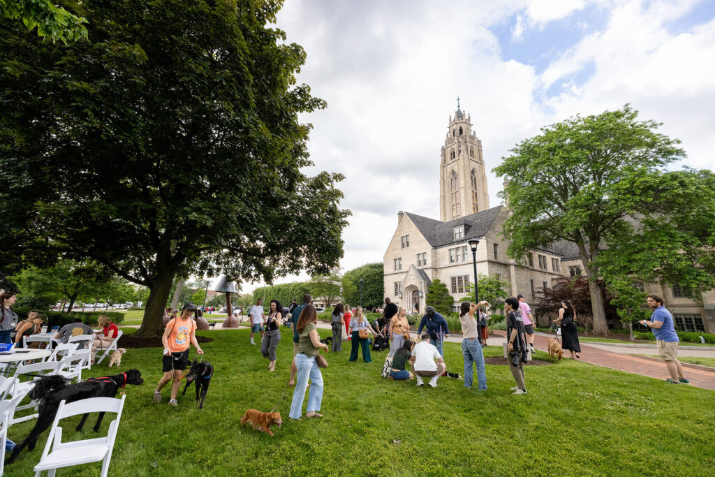 People gathered for an event outside on MAG's grounds with their dogs.