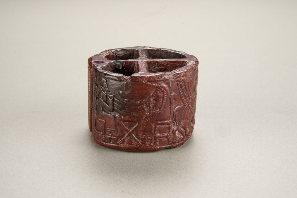 Red stone toiletry box engraved with animals, natural and mythological.