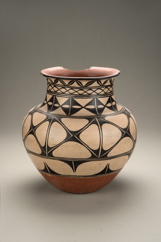A jar decorated with a cream slip based and dark black geometric patterns.