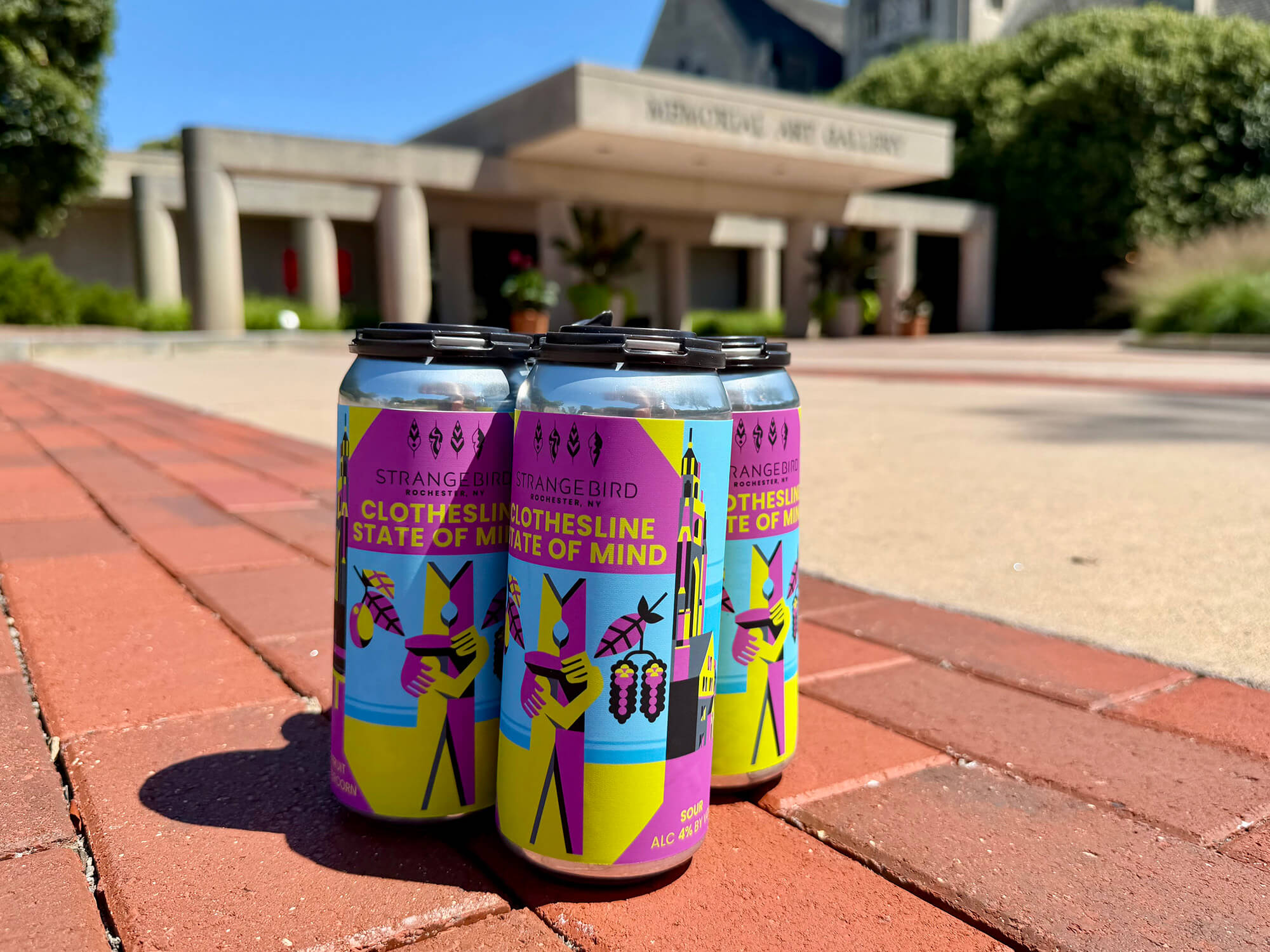 Colorfully-labeled cans of beer on the sidewalk outside MAG's main entrance.